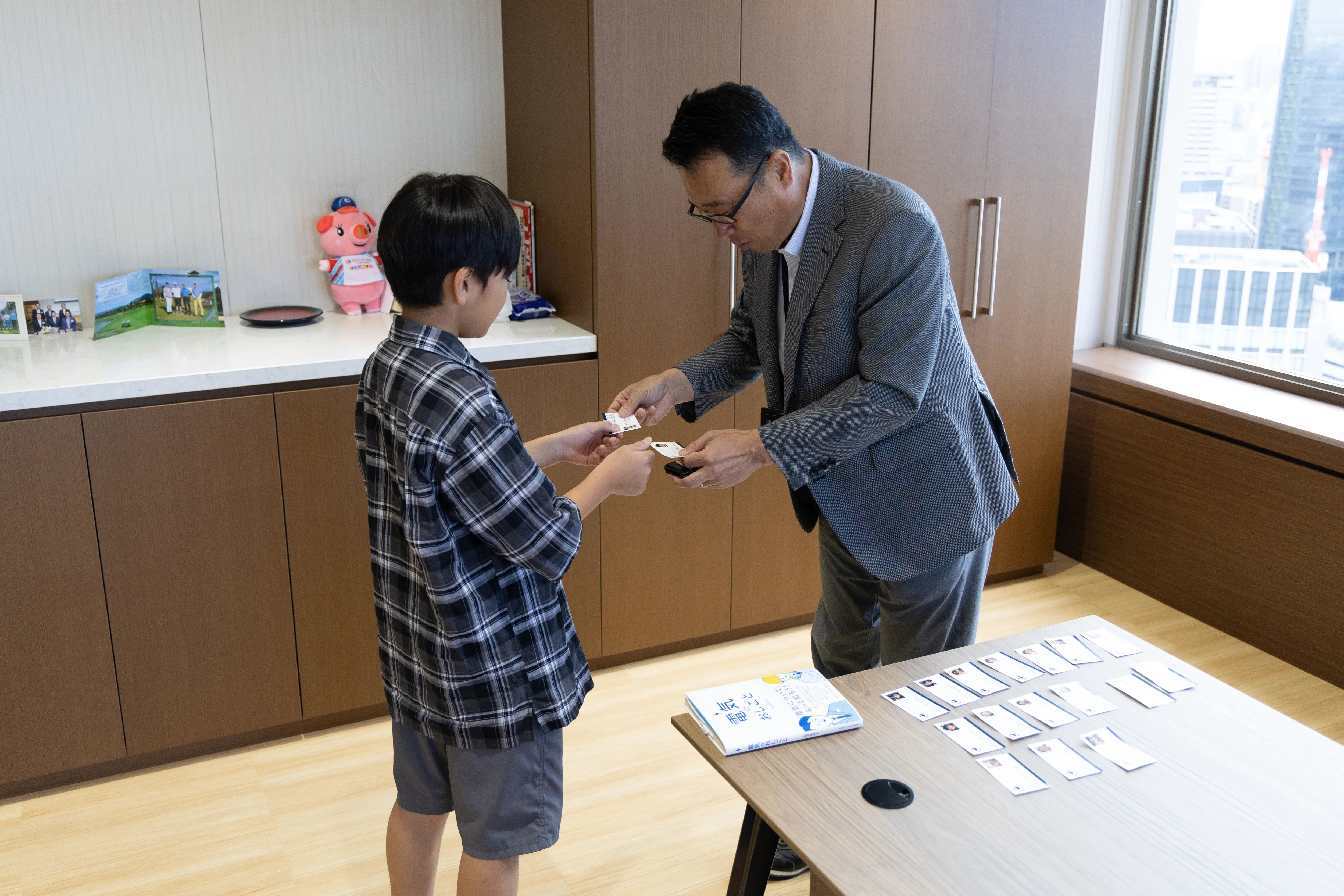 子どもたちが社長と名刺交換をしている様子